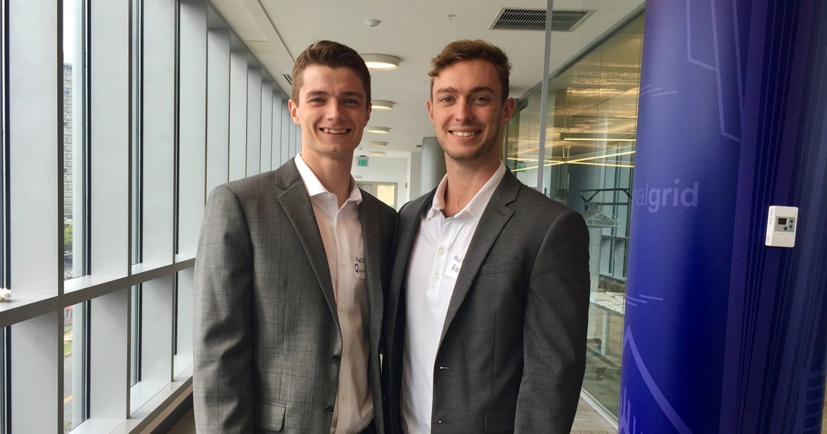 Quinn King and Alec Gillinder in professional attir pose for a photo