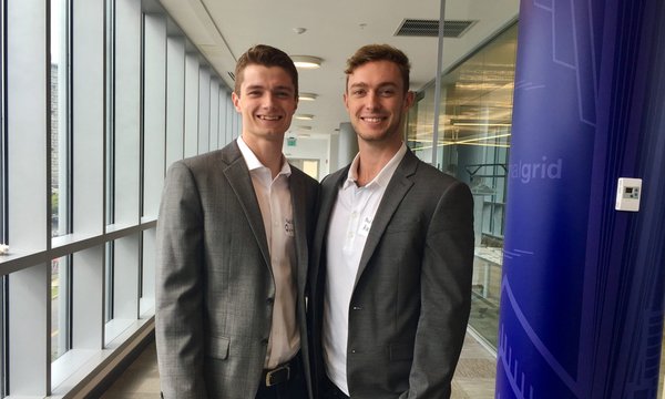 Quinn King and Alec Gillinder in professional attir pose for a photo