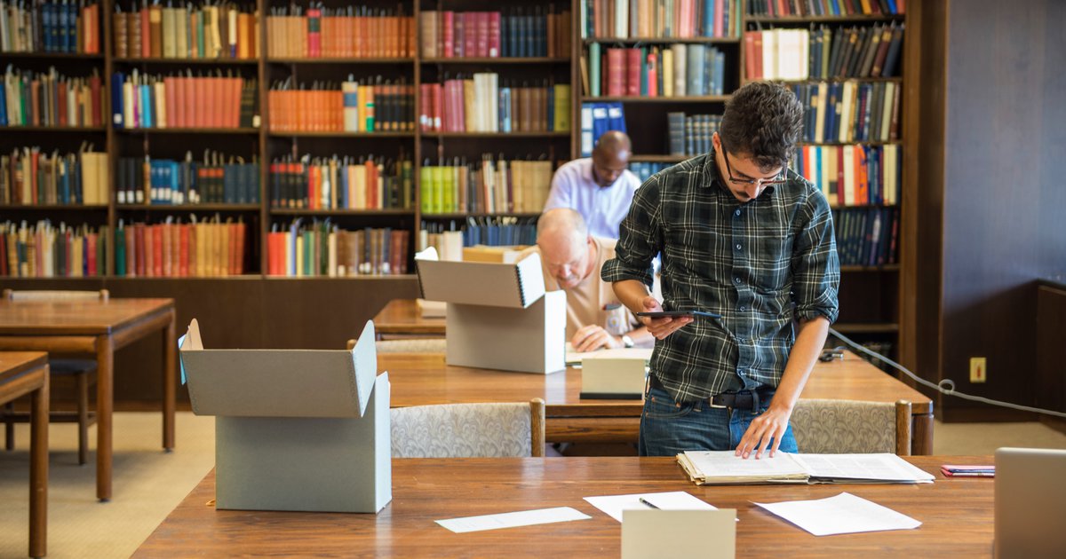 Special Collections Research Center Reading Room with man working at a wooden table and bookshelves in the background