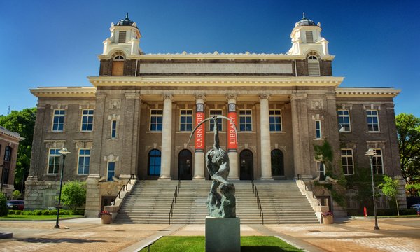 Front view of Carnegie Library and Saltine Warrior statue on a sunny day