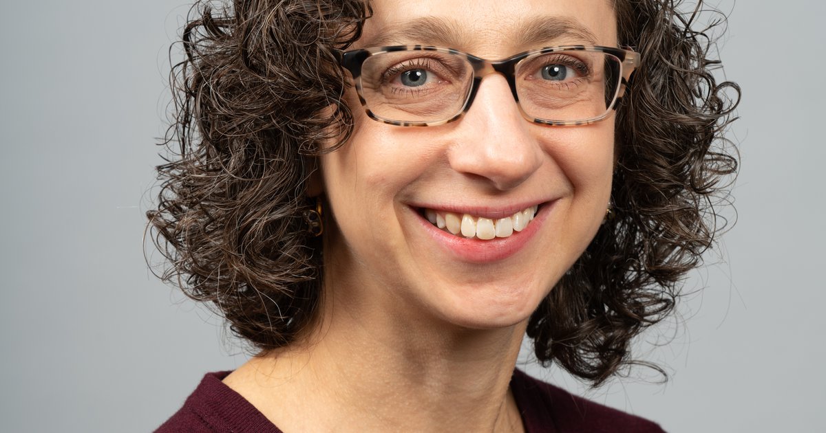 head and shoulders of person with curly hair and glasses