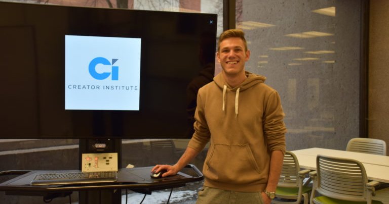 Randy Ginsburg stands in front of a TV