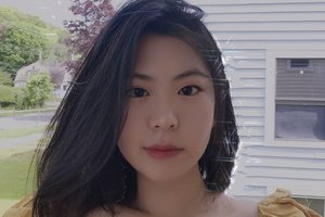 Renee Yu in yellow top looking at the camera