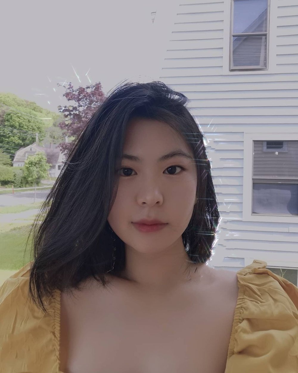 Renee Yu in yellow top looking at the camera