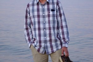 Ricardo Sanchez pose for a photo on the beach, holding his shoe