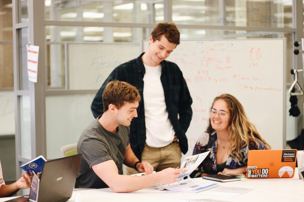 three people working at table together