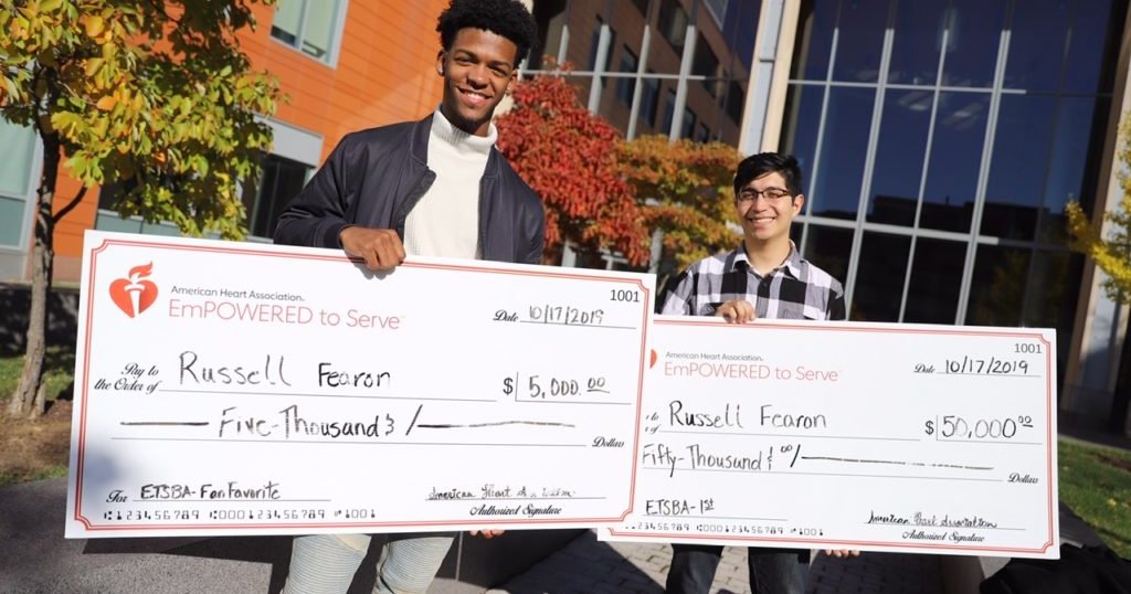 two men holding oversized checks