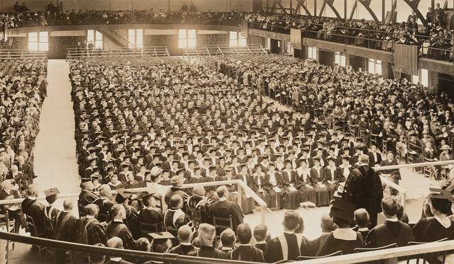 Sepia tone archival photo of of Chancellor James Roscoe Day speaking at Commencement in Archbold Gymnasium in 1916, from the Syracuse University Photograph Collection of the University Archives.