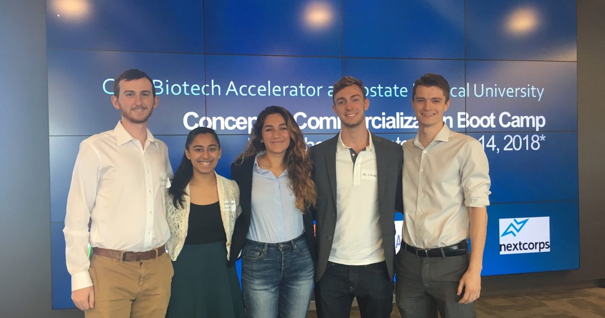 5 students in front of large screen