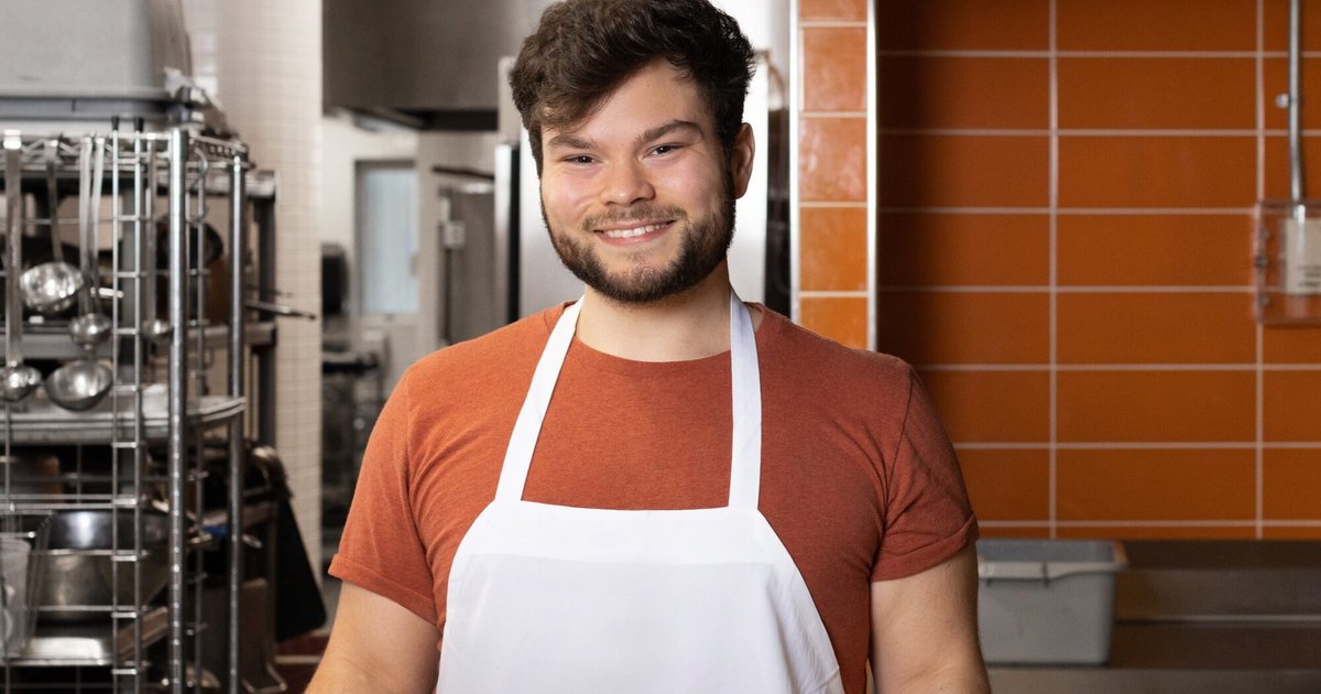 Ethan Tyo in brown t-shirt and white apron in the kitchen