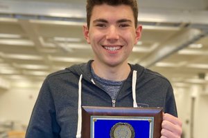 young man holding plaque