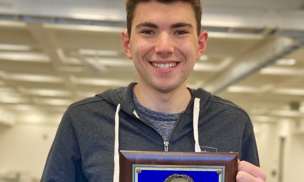 young man holding plaque
