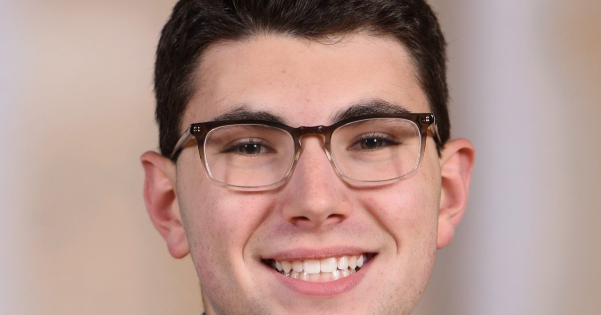 headshot of Sam Hollander smiling at the camera