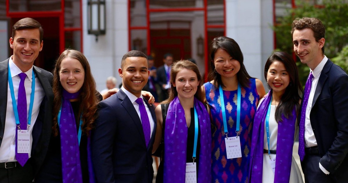7 people posing with purple scarves/ties