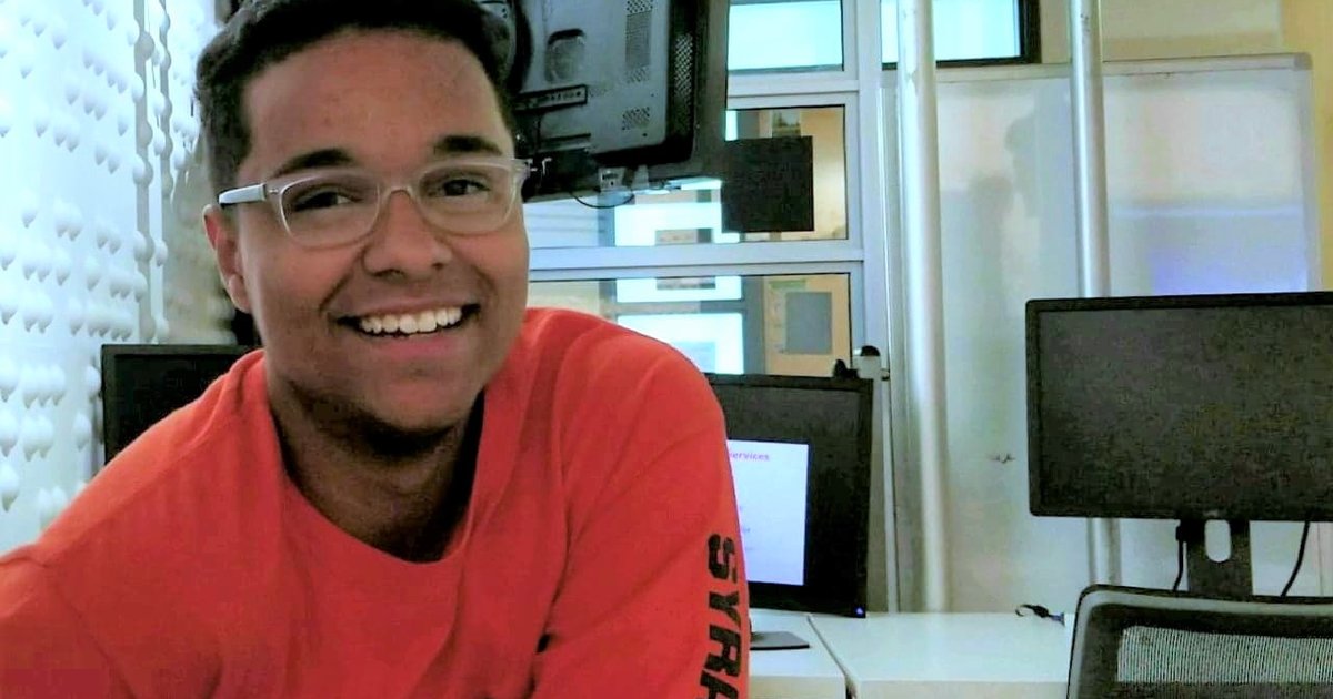 Man in red shirt poses for a photo