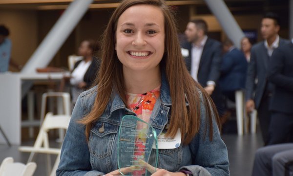 woman smiling with glass award in hand