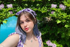 student with aqua water and purple flowers