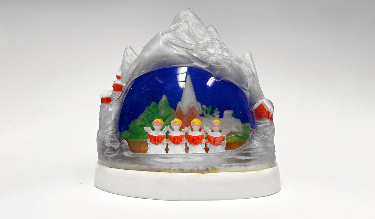 plastic snow dome with mini people singing from hymnal