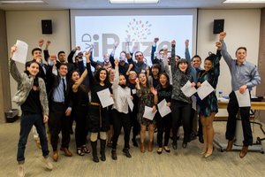 group of students jumping in air with iPrize logo on screen behind them
