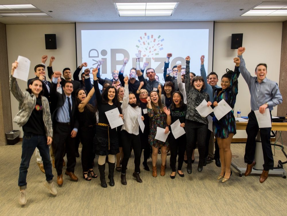 group of students jumping in air with iPrize logo on screen behind them
