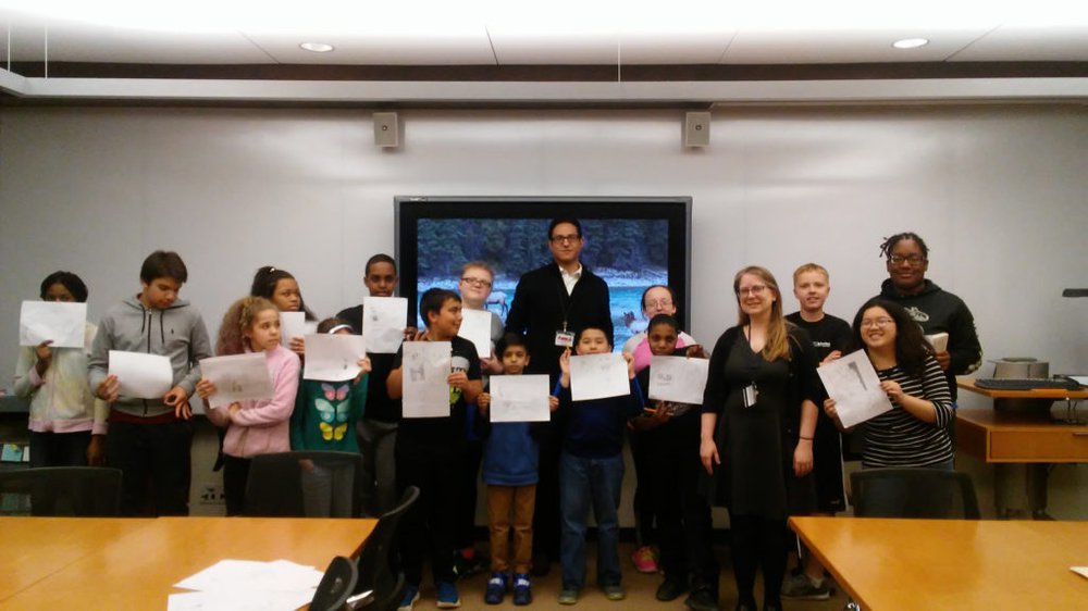 Students holding up comics they drew