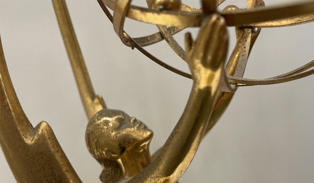 Close up of gold Emmy award statue holding an open globe
