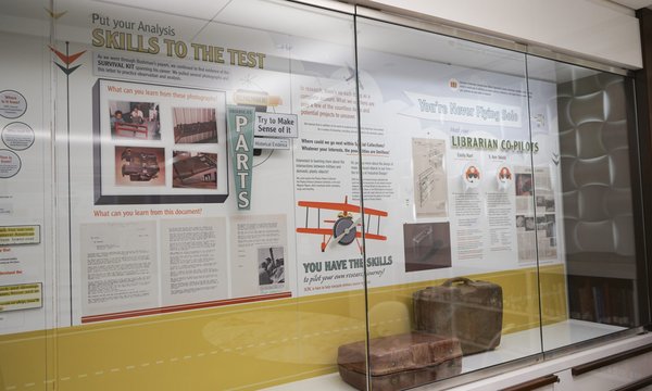 Survival Kit exhibition with glass display cases and mounted photos and descriptions