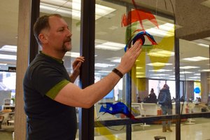 Tom Hall looks over an art piece being installed this week by VPA students in Bird Library