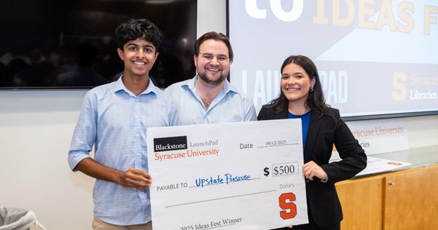 three people posing with giant check