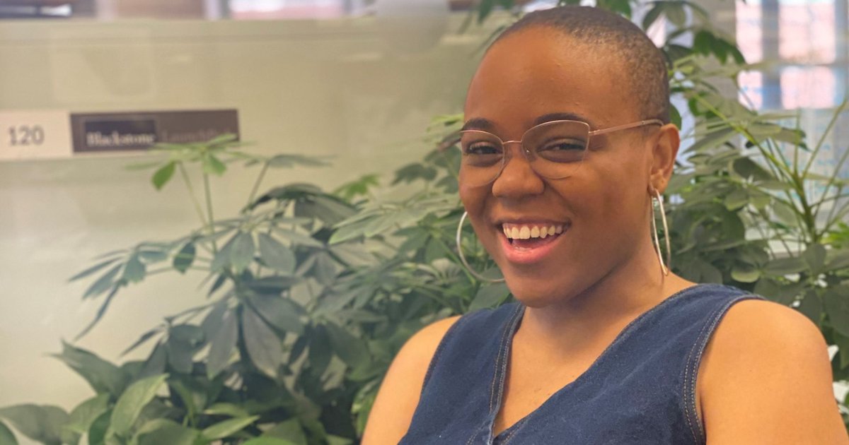 student in front of plants in the library