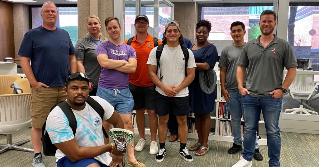 A group of Warrior Scholars pose for a group photo in front of the Blackstone LaunchPad office