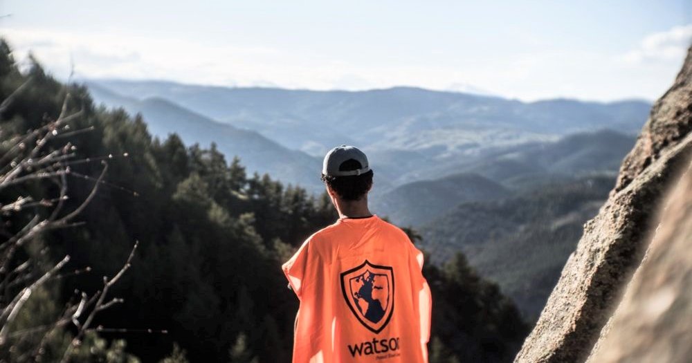 Man in orange shirt overlooking the mountain
