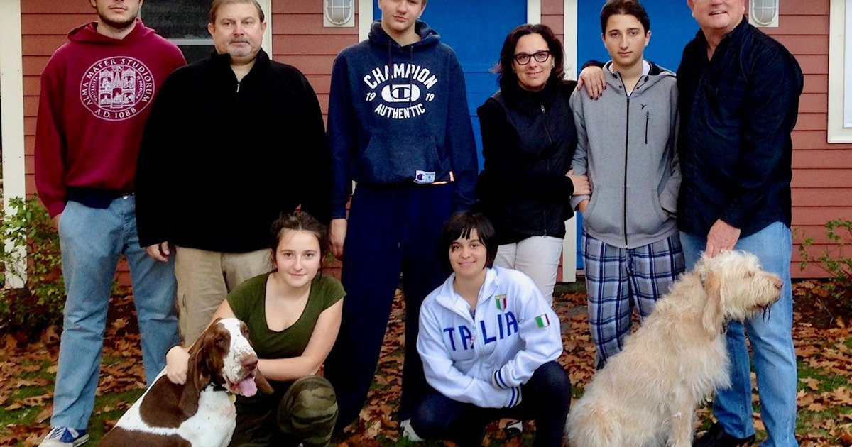 Eight members of the Zaccai family posing outdoors with their two dogs