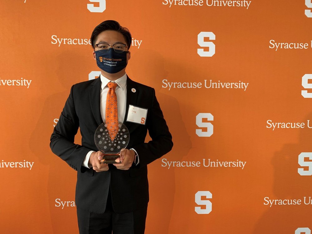 Ze Zing holds an Orange Circle Award plague