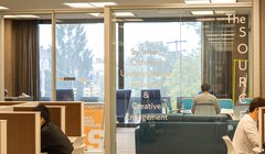 glass enclosed room with words Syracuse Office of Undergraduate Research and Creative Engagement printed on glass wall