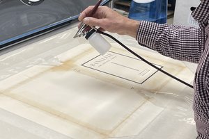 hand spraying light mist on book cover on work table