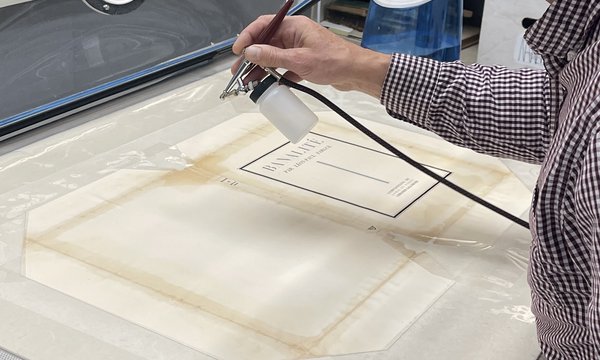 hand spraying light mist on book cover on work table