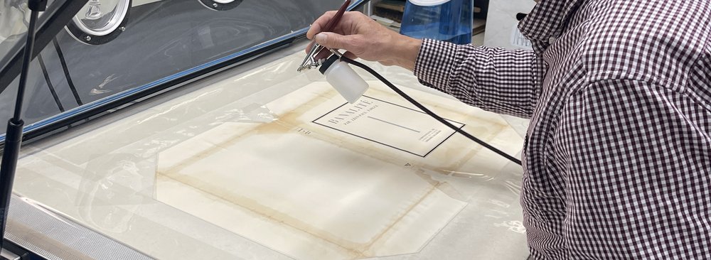 hand spraying light mist on book cover on work table