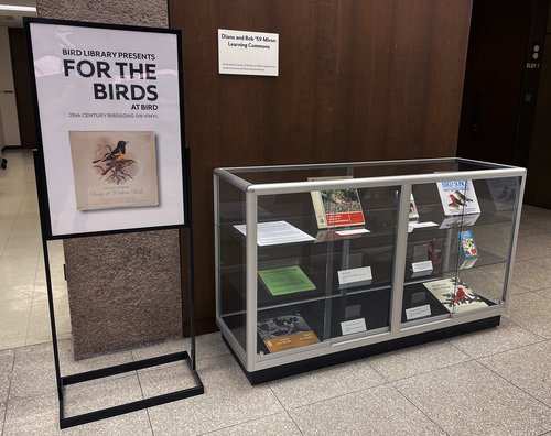 poster "For the Birds" on left next to glass display case
