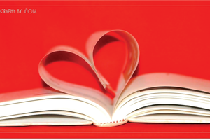 book open with pages making heart with red background
