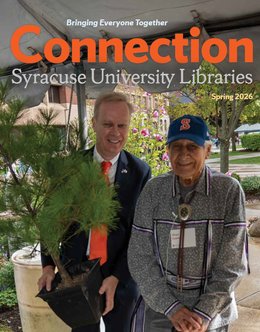 chancellor in suit and orange tie holding sapling tree next to indigenous faithkeeper wearing SU baseball hat