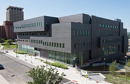 modern multi-floor gray building with sections that protrude from main building