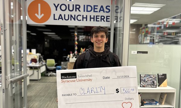 student holding large check