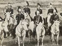 two rows of men in costumes atop horses