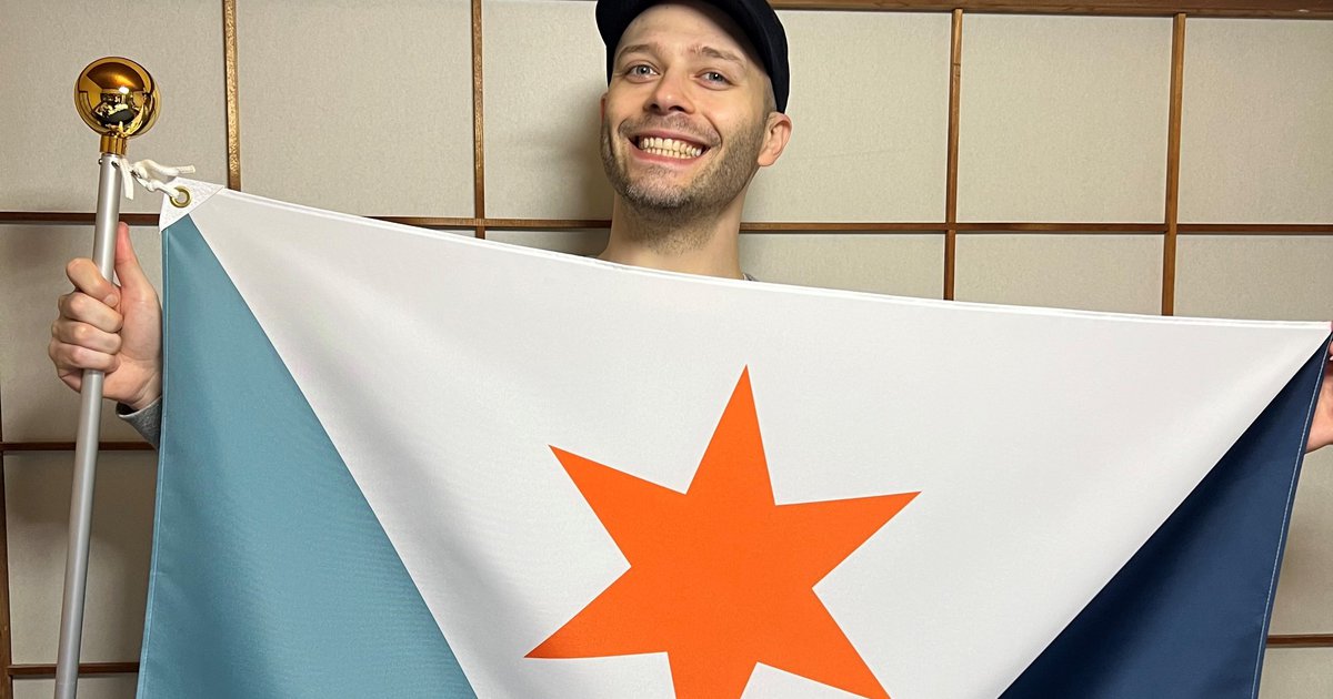 person smiling and holding flag