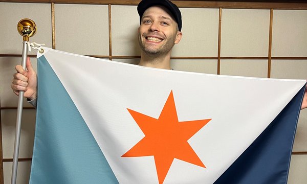 person smiling and holding flag