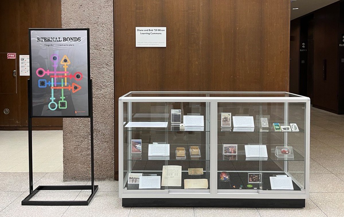 glass display case with items inside on 1st floor of Bird Library. Next to case is a poster with title "Eternal bonds"