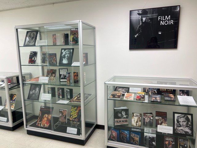 display cases with videos, photos and books