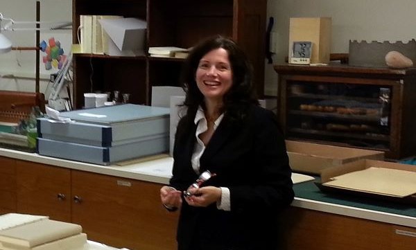 person standing in front of table with rolled up papers and books