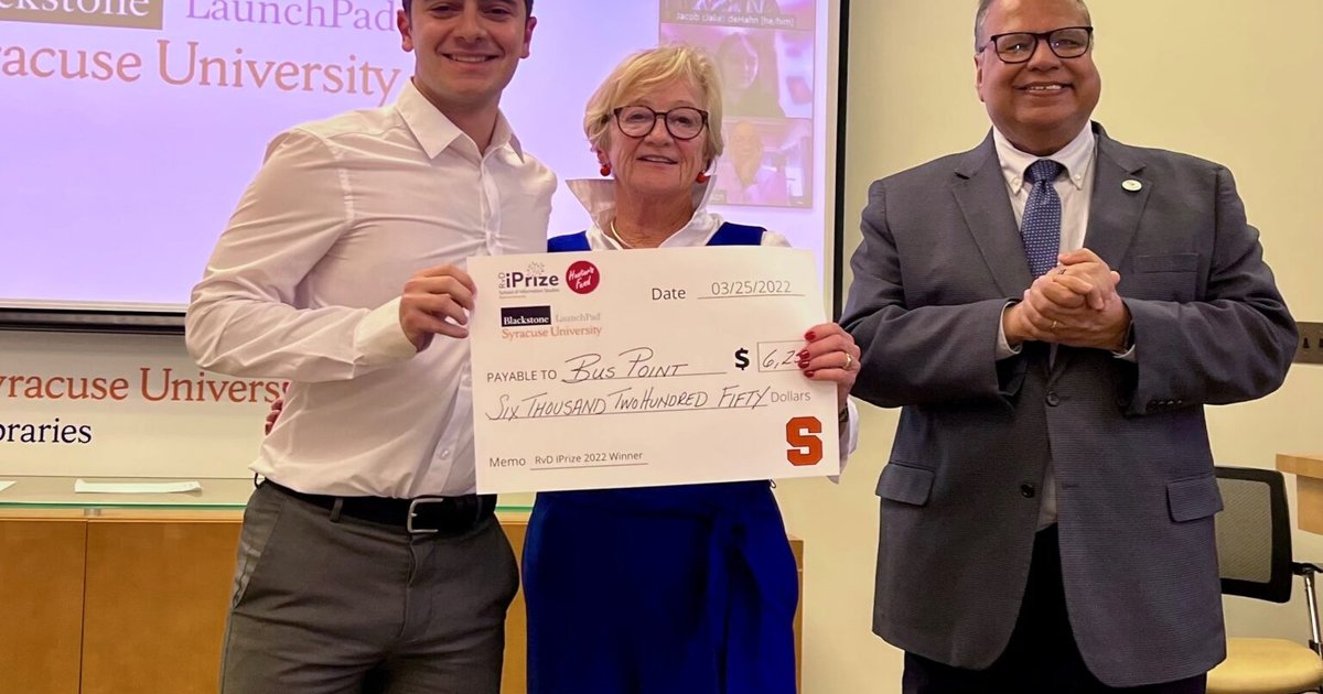 three people posing holding giant check